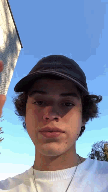 a young man wearing a baseball cap and a white shirt