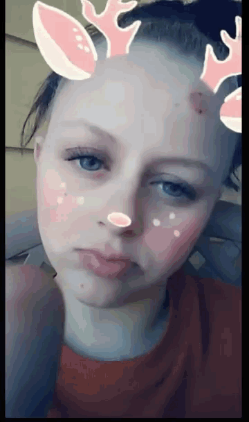 a girl wearing a reindeer headband on her face