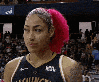 a woman with pink hair is wearing a jersey with car max on it
