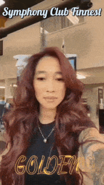 a woman with long red hair is standing in front of a sign that says symphony club funnest golden !!