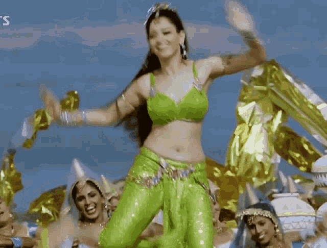 a woman in a green top and green pants is dancing