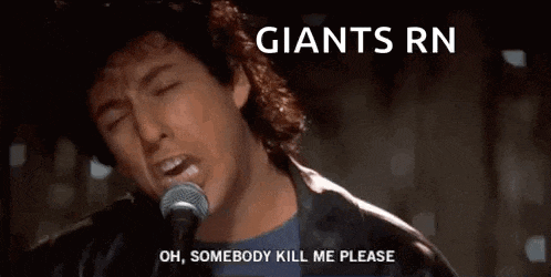 a man is singing into a microphone with the words `` giants rn '' written above him .