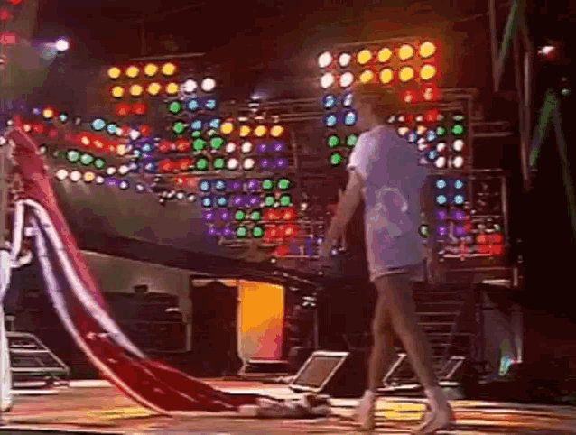a woman is walking on a stage with a red and white flag on it .