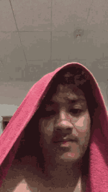 a man with a pink towel covering his head