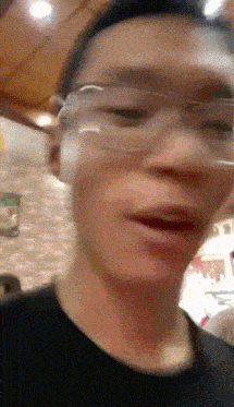 a close up of a person wearing glasses with a blurry background