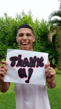 a young man is holding a sign that says thank you