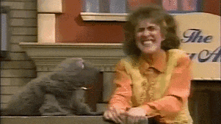 a woman is sitting next to a teddy bear on a sidewalk .