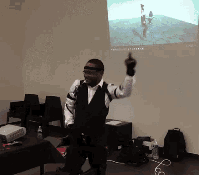 a man in a suit is holding a gun in front of a screen that says ' a ' on it