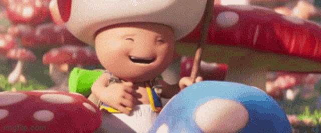 a cartoon toad is sitting on a blue mushroom .