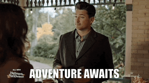 a man in a suit is talking to a woman and the words adventure awaits are on the screen