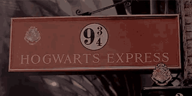 a red sign that says `` hogwarts express '' is hanging from the side of a building .