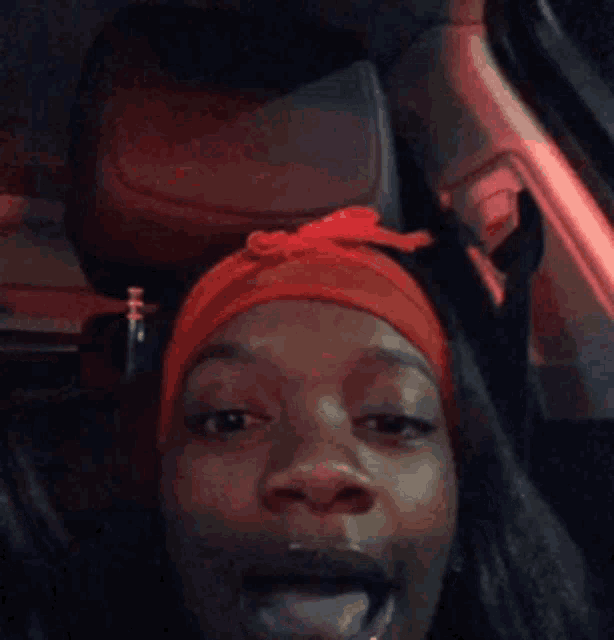 a woman wearing a red headband is sticking her tongue out