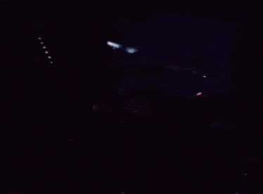 a man playing drums in a dark room with a microphone