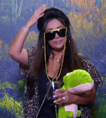 a woman wearing sunglasses holds a stuffed frog and a wine glass