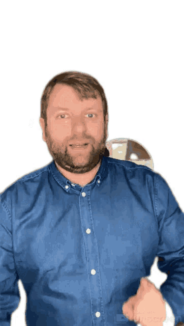 a man with a beard is wearing a blue shirt and pointing