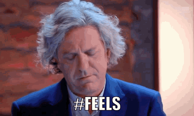 a man with gray hair says #feels in a blue suit
