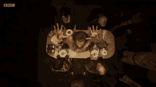 a group of people sitting around a table with bbc written on the bottom left