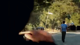 a man wearing a blue shirt with the number 33 on it is walking down the street .