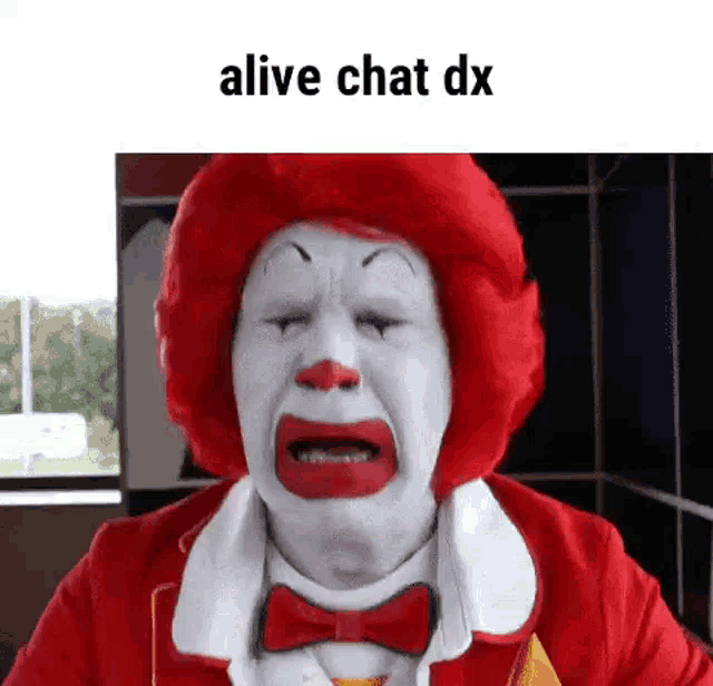 a mcdonald 's clown is crying with his eyes closed and a red wig .