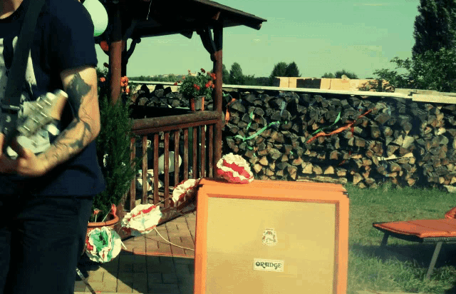 a man playing a guitar with an orange amplifier in front of him