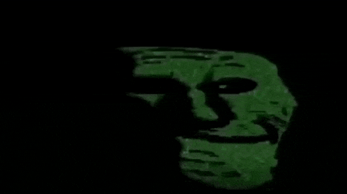 a troll face is glowing in the dark with a green background .