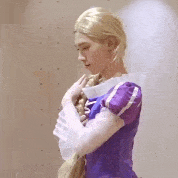 a man is wearing a purple dress and a wig .