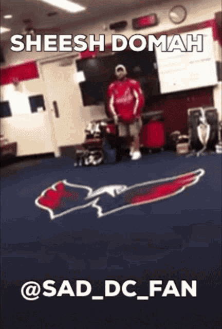 a man in a red shirt stands in front of a washington nationals logo on the floor