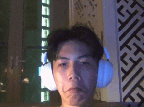 a man wearing headphones looks at the camera in front of a geometric pattern