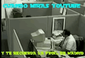 a man is sitting at a desk in an office cubicle with the words cuando miras youtube written above him