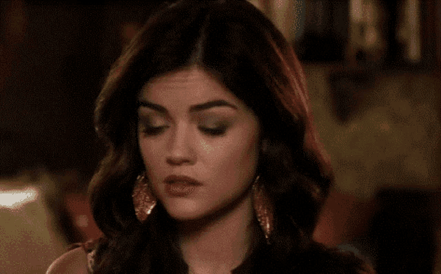 a close up of a woman 's face with earrings on .
