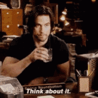 a man is sitting at a desk with a sign that says " think about it "
