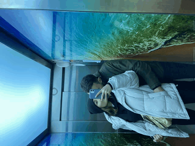 a man and woman taking a picture in an elevator