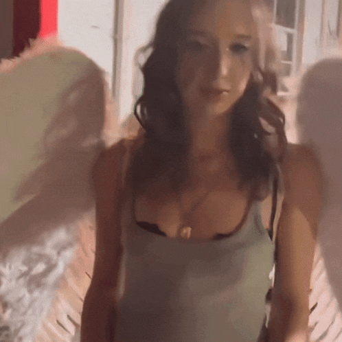 a blurry picture of a woman in a tank top and black bra
