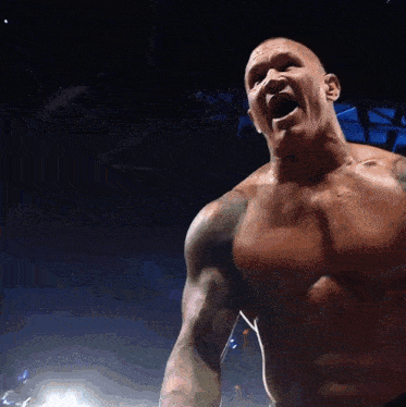 a man without a shirt is shouting in the dark