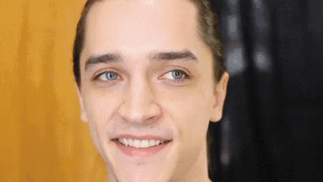 a close up of a man 's face with a smile