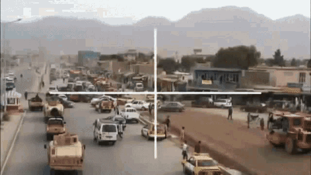 a sniper scope is pointing at a busy street with cars and trucks