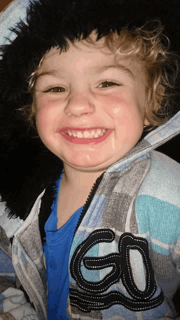 a young boy wearing a jacket that says go