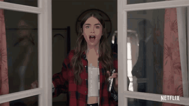 a woman in a red plaid shirt is standing in front of a netflix window