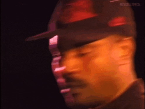 a close up of a man wearing a hat and looking at the camera .