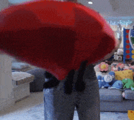 a person in a living room with stuffed animals on the floor