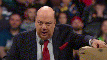 a bald man in a suit and tie is standing in front of a microphone