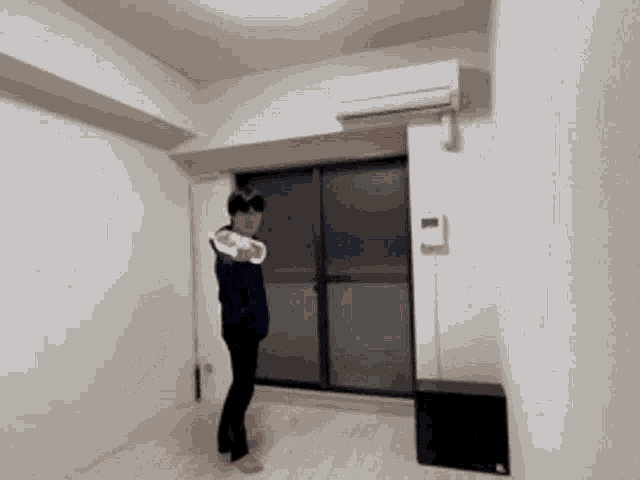 a person is standing in a room with a remote control on the wall