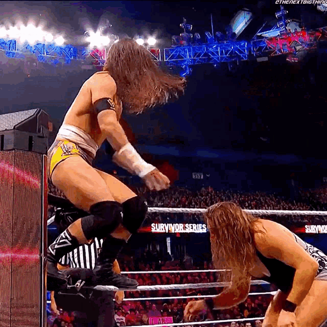 a wrestler is jumping over another wrestler in a wrestling ring that says survivor series