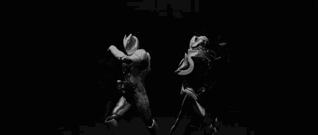 a black and white photo of a superhero kicking another superhero .