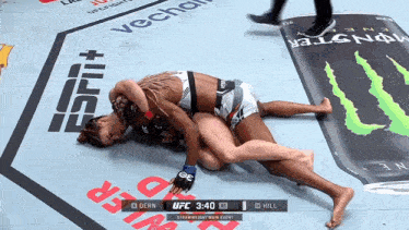 a female fighter is laying on the ground during a match sponsored by espn
