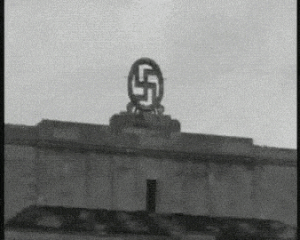 a black and white photo of a building with a swastika on the top .