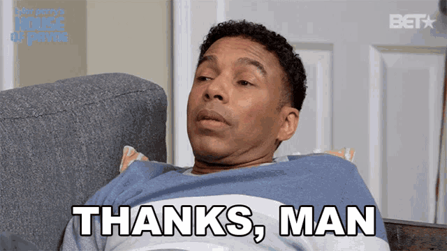 a man is sitting on a couch and says " thanks man "