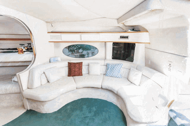 a curved couch with pillows on it in a room with a window