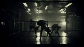 a woman is dancing in a boxing ring in a black and white photo .