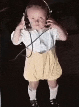 a baby is wearing headphones and standing in the dark